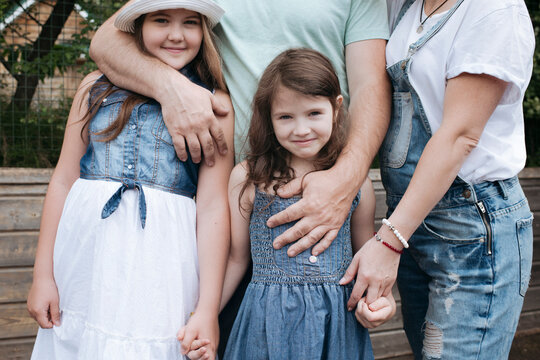 Girls standing with parents at back yard