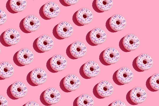 Pattern of sweet doughnuts against pink background