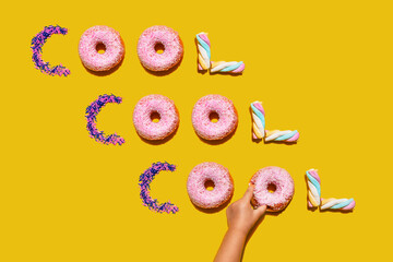 Hand of baby girl touching sweets arranged into single repeated word