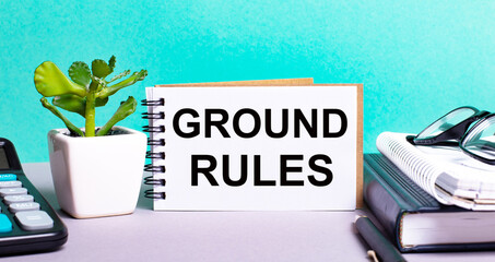 GROUND RULES is written on a white card next to a potted flower, diaries and calculator....