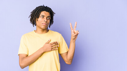 Young african american rasta man taking an oath, putting hand on chest.