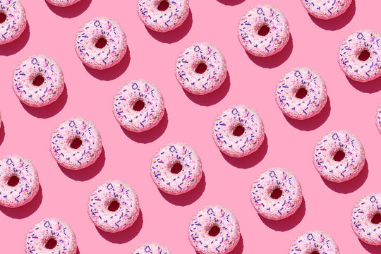 Pattern of sweet doughnuts against pink background