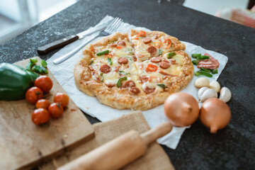 Italian pizza with tomato topped with melted cheese on a table