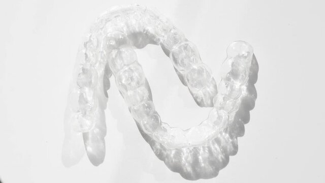 Invisalign removable and invisible retainer on white surface, modern tooth transparent aligners or braces to straighten teeth in cosmetic dentistry and orthodontics