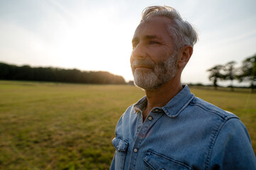 Content mature man on a meadow in the countryside