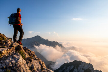 Man admiring view while standing on mountain peak at Bergamasque Alps, Italy