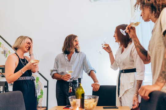 Young friends enjoying wine during party at home