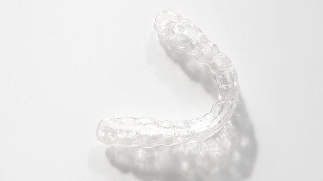 removable and invisible retainer on white surface, modern tooth transparent aligners or braces to straighten teeth in cosmetic dentistry and orthodontics