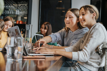 Teenage girls studying and learning from home, using laptops