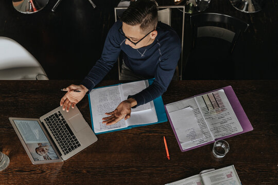 Young man studying from home, using laptop