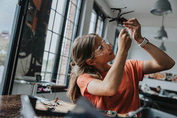 Teenage girl assembling miniature helicopter at home