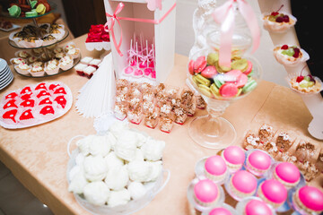 Delicious and tasty dessert table with cupcakes and shots at reception closeup