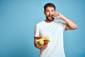 dark background handsome man with a beard holding fresh fruit and lifestyle transparent cup