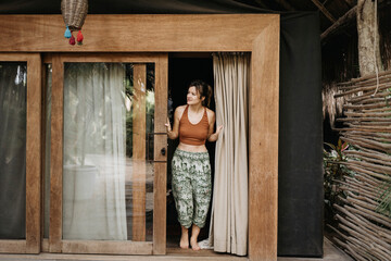 Smiling woman opening terrace door
