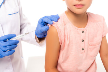 Cropped view of doctor in latex gloves holding syringe near child isolated on white