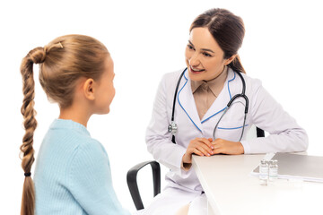 Selective focus of smiling pediatrician looking at child near vaccine and paper folder isolated on white