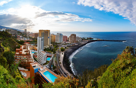 Spain, Canary Islands, Puerto de la Cruz, Playa Martianez and surrounding buildings at sunset