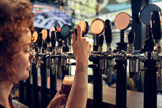 Female barkeeper tapping beer in a pub
