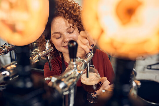 Female barkeeper tapping beer in a pub
