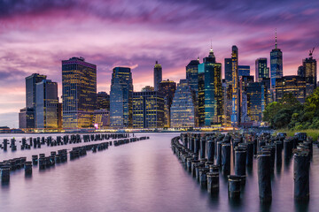 Scenic view of mooring posts in East River with Lower Manhattan in background during sunset