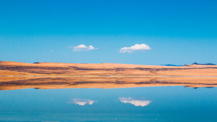 Scenic view of clouds reflecting in lake along coastline
