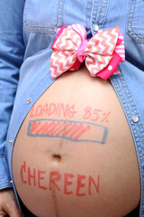 Asian pregnant woman put a pink ribbon above belly to waiting newborn