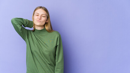 Fototapeta premium Young blonde woman isolated on purple background having a neck pain due to stress, massaging and touching it with hand.