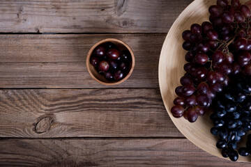 Red and purple grapes branches on rustic background