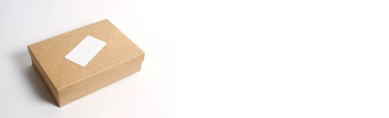 Cardboard craft box with cover on white background top view. The concept of delivery, mail, destinations, the quarantine period is relevant. Copy space.