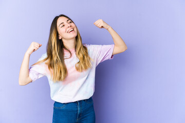 Fototapeta na wymiar Young caucasian woman isolated on purple background raising fist after a victory, winner concept.