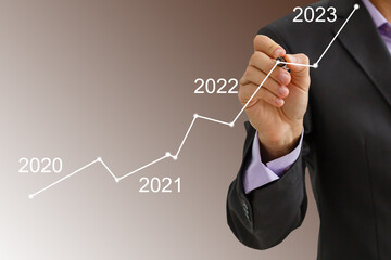 Man's hand pointing graph of success in 2022 year. Growing business concept