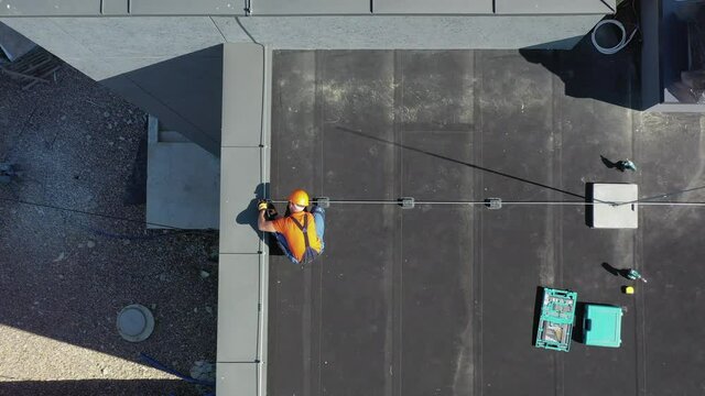 Aerial View of Metal Roof Lightning Protection Construction Building by Caucasian Roof Worker