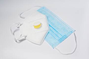 Respirator with exhalation valve and medical protective mask isolated on a white background