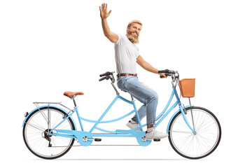 Smiling bearded man riding a tandem bicycle alone and waving