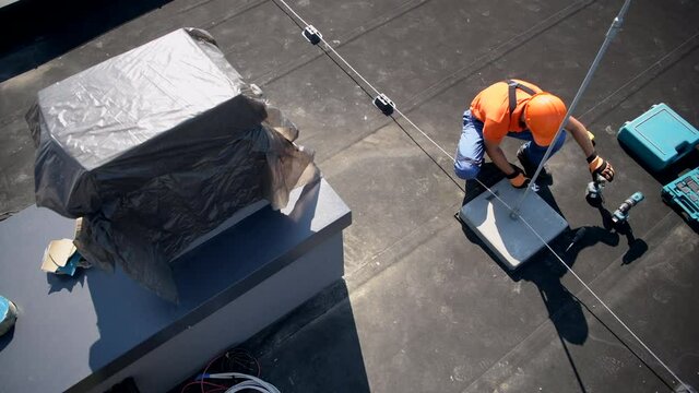 Caucasian Worker Adjusting Metal Rod of Lightning Protection System