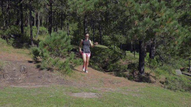 Mujer activa corriendo al aire libre en la montaña, haciendo entrenamiento de resistencia, para un estilo de vida saludable