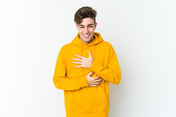 Young caucasian man isolated on white background laughs happily and has fun keeping hands on...