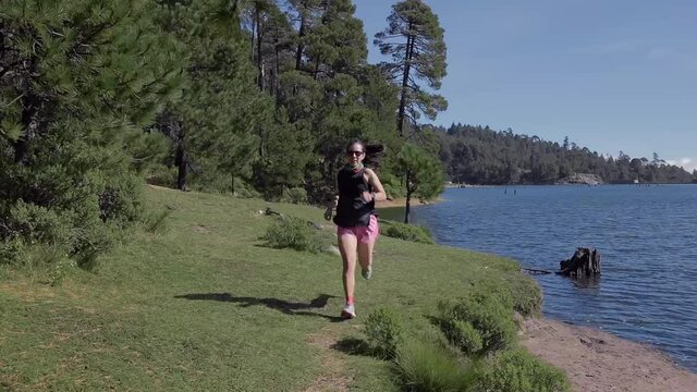 Mujer activa corriendo al aire libre en la montaña, haciendo entrenamiento de resistencia, para un estilo de vida saludable