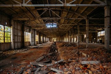 Abandoned ruined large industrial hall with garbage waiting for demolition