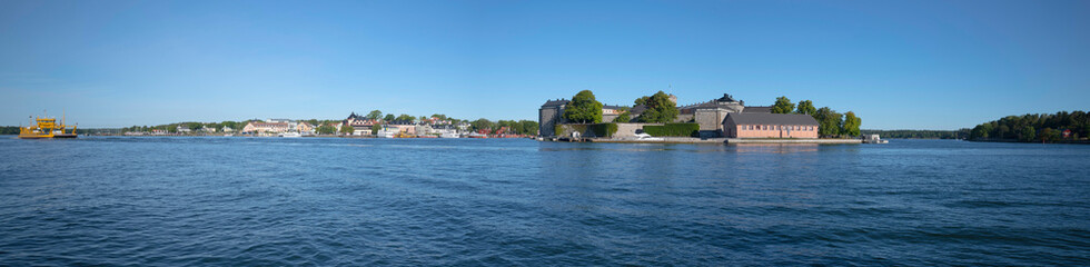 Fototapeta na wymiar Panorama view over the islands Vaxön, Vaxholmen and Rindö. An old castle, car ferries and commuter boats to the Stockholm archipelago.
