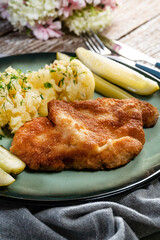 Pork chop served with mashed potatoes and pickled cucumber.