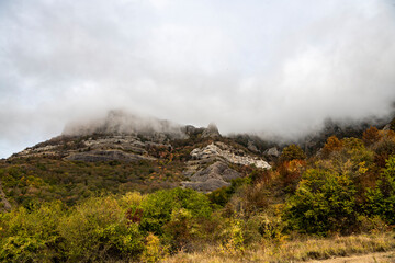 mountains at sunset in fog and gray clouds