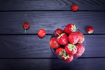 Fresh red strawberries on a dark wood background. Place for text