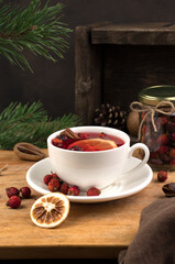 Christmas drink with cinnamon and lemon on a wooden background. Side view, vertical orientation. The concept of New Year and Christmas.
