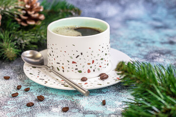 A cup of delicious aromatic coffee. It is placed on a substrate made of coffee beans. New Year holiday concept. On a light background.