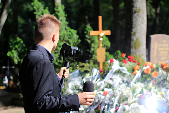 The professional man transmitting the funeral live. Funeral recording. Cameraman at the cemetery recording the burial. Funerals online. Funerals live.