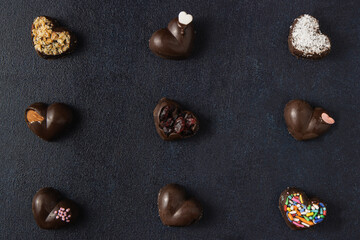 Fototapeta na wymiar Chocolate pralines isolated on a dark background. Top view, flat lay.