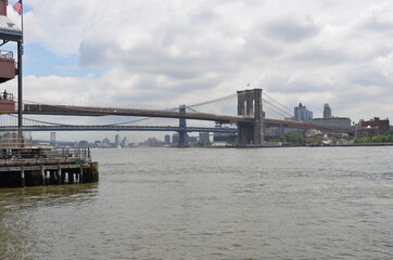 View of the Brooklyn Bridge over the Hudson River in New York with skyline in the background under...