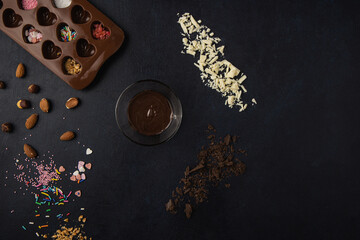 Obraz na płótnie Canvas Chocolate pralines ingredients isolated on a dark background. Top view, flat lay.