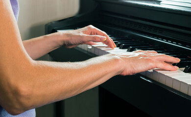 Unrecognizable young caucasian female plays the piano.